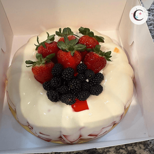 Large mosaic and tres leches gelatin, decorated with fruits and whipped cream.