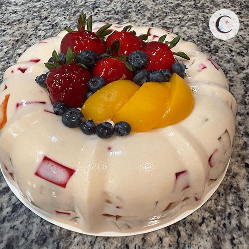 Large mosaic and tres leches gelatin, decorated with fruits and whipped cream.