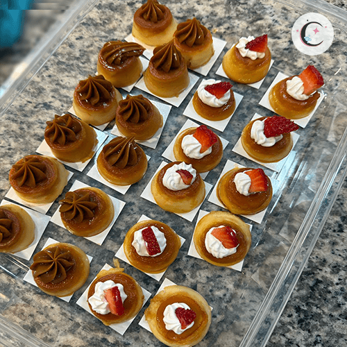 Mini flan, decorated with whipped cream, strawberries, and dulce de leche.