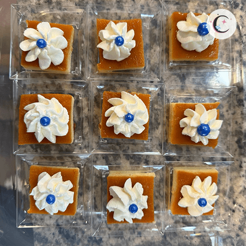 Mini flan, topped with whipped cream and a decorative pearl.